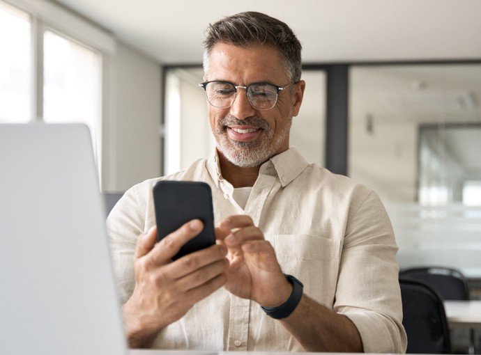 Man with glasses looking at phone